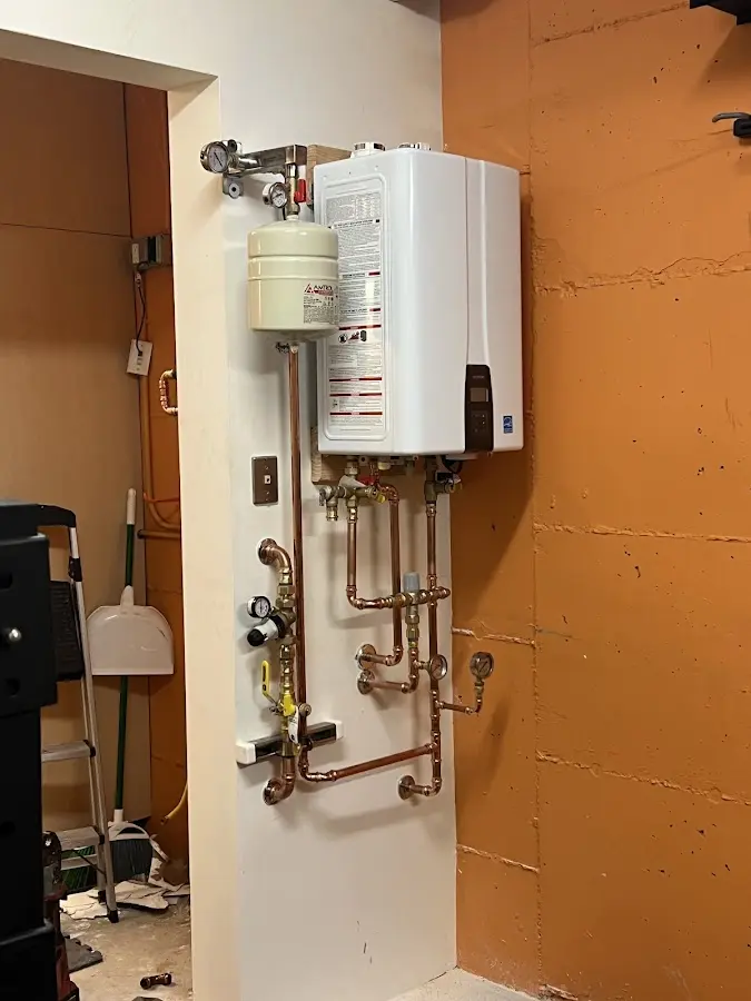 Plumbing technician inspecting water heater connections in River Ridge